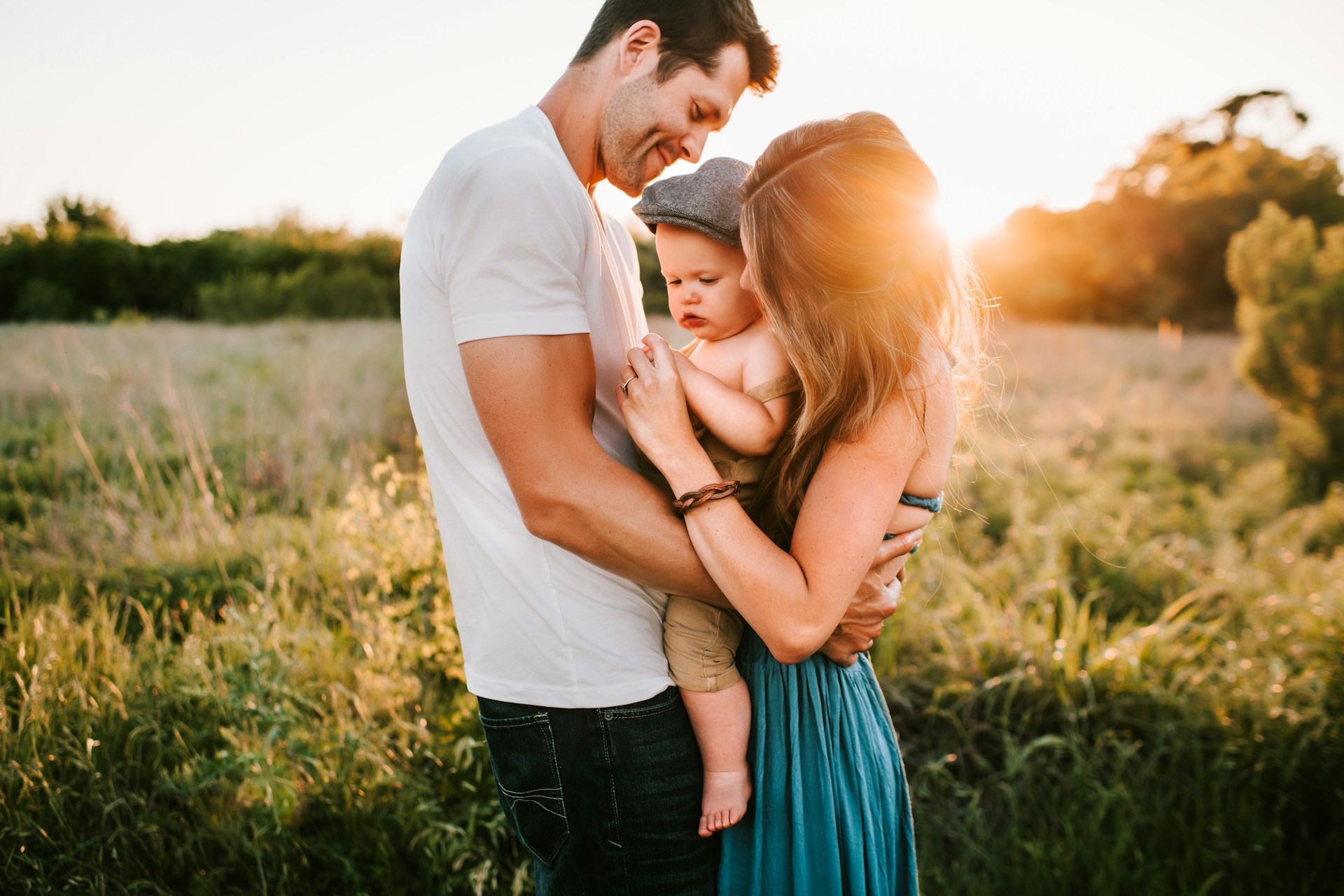 A family together in a field at sunset