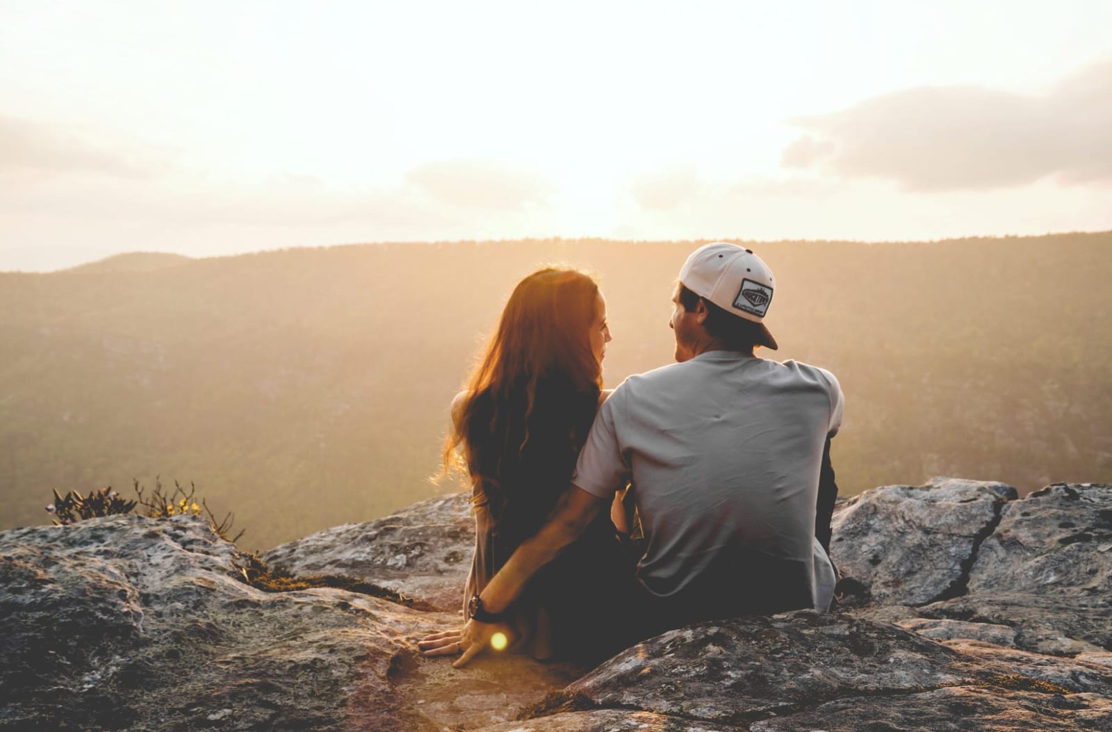 Couple watching the sunset together on a rocky outlook